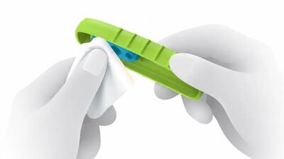 Gloved hands wiping a green Yewtwist with a disinfectant wipe
